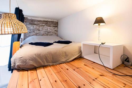 南特Le Perchoir de Niro的一间卧室配有一张床和一张带台灯的桌子