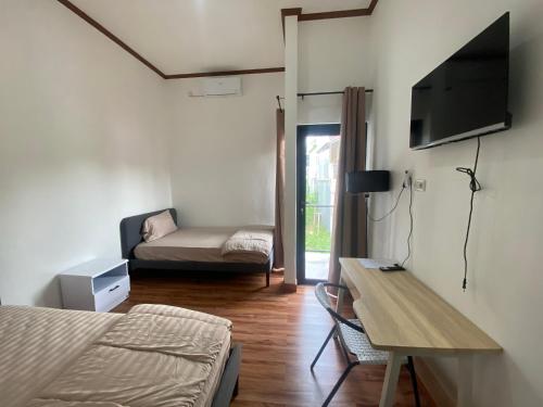巴厘巴板EMWEKA Residence Balikpapan的一间卧室配有一张床、一张桌子和一张沙发