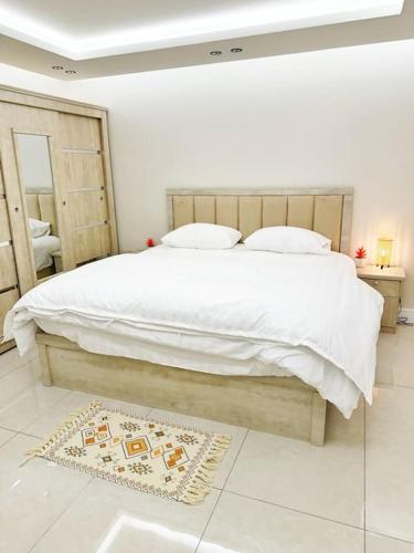 利雅德شقة بغرفتين نوم وبلكونة خاصة ١٥的白色卧室配有大床和地毯