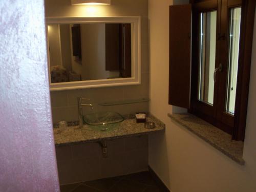 BettolaPoggio d'Incanto的一间带玻璃水槽和镜子的浴室