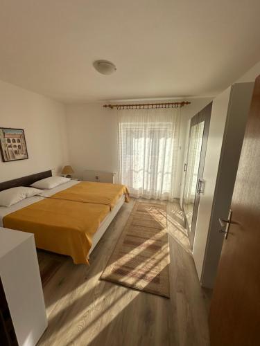 塞尼Apartment & Apartment Studio Deželjin的一间卧室设有一张床和一个大窗户