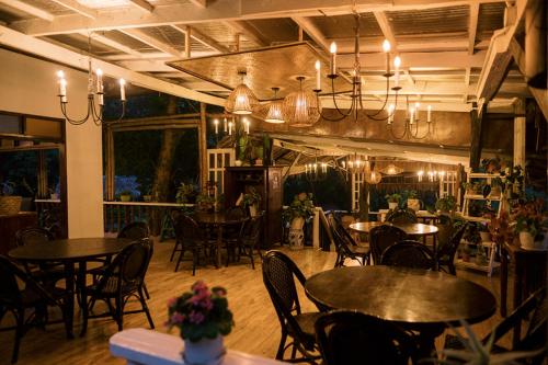 MajayjaySamkara Restaurant and Garden Resort的用餐室配有桌椅和吊灯。
