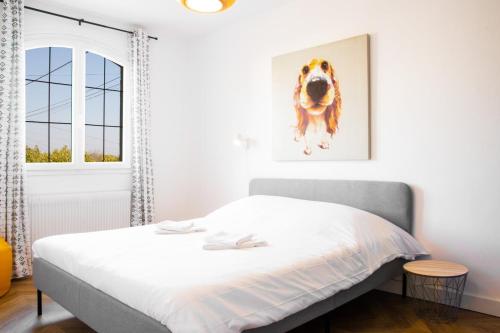若奈克朗La Pergola - Superbe maison au Futuroscope !的卧室配有一张床铺,墙上挂着狗图片