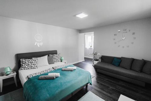 博加奇Sunny Garden Apartment的一间卧室配有一张床、一张沙发和一个时钟