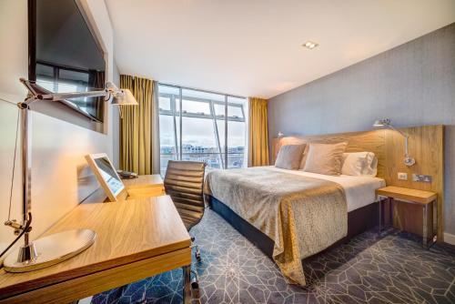 格拉斯哥Apex City of Glasgow Hotel的配有一张床和一张书桌的酒店客房