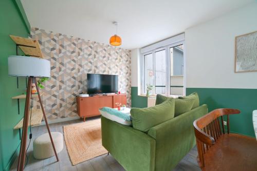 普瓦捷Le Relais Poitevin - Grand T3 proche gare的客厅配有绿色沙发和电视