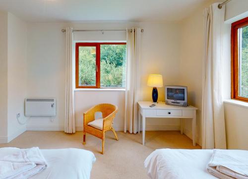 基拉卢Lakeside HH No 30 - 2 Bed的一间卧室配有书桌、椅子和电视。