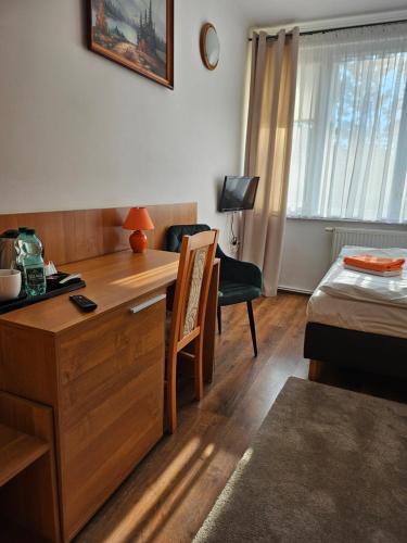 弗沃茨瓦韦克"Hel" Wieniec Zdrój的一间设有一张桌子和一张床的房间,一间设有一张床铺的房间