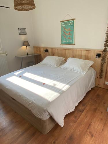 滨海苏拉克Hôtel L'Arbousier的一间卧室配有一张带白色床单的大床