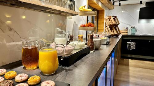里茨勒恩Alpen Lodge Riezlern的厨房柜台,备有橙汁和甜甜圈