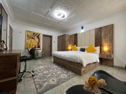 阿布贾UrbaN RootZ的酒店客房,配有一张床、一张桌子和椅子