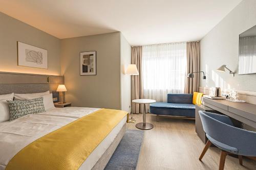 慕尼黑欧洲酒店的酒店客房设有一张大床和一张蓝色的沙发。