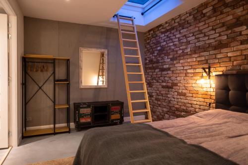阿尔克马尔Drive-in appartement centrum Alkmaar的一间设有床铺的房间和砖墙上的梯子