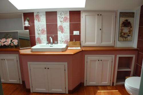 Belforte del ChientiB&B Antegiano的浴室设有水槽和红白瓷砖
