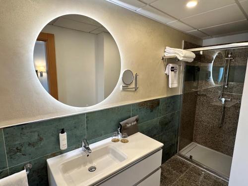 托莱多Antídoto Rooms Zocodover的一间带水槽、镜子和淋浴的浴室