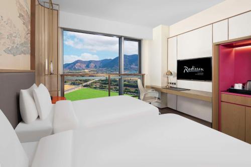 苏州苏州纽威丽筠酒店的酒店客房设有一张大床和一台电视。