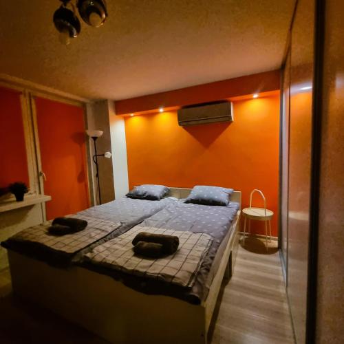 克拉科夫Orange Apartment Kraków的一间卧室配有一张床,上面有两条毛巾