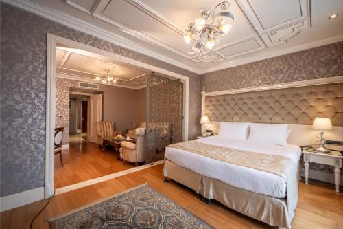 伊斯坦布尔塔克西姆中央宫酒店的一间带大床的卧室和一间餐厅