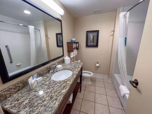 切罗基Cherokee Inn的一间带水槽、卫生间和镜子的浴室