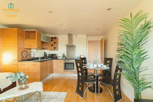 利兹1 Bedroom Apartment by Homevy Relocations Short Lets & Serviced Accommodation Leeds Dock - Stylish and Convenient的厨房以及带桌椅的用餐室。