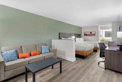 奥兰多Quality Inn & Suites Orlando East - UCF Area的酒店客房设有一张沙发和一张床