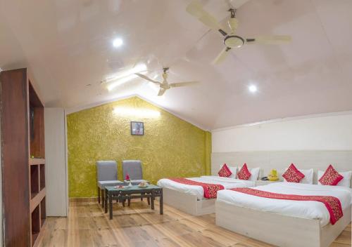 兰纳加Mannat Corbett Resort的酒店客房设有两张床和一张桌子。