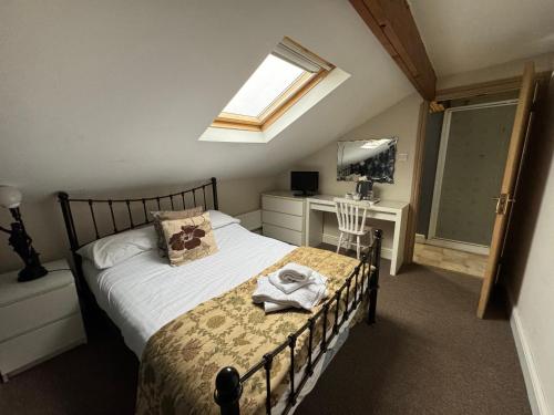 霍特惠斯尔Saughy rigg farm的一间卧室配有一张床、一张书桌和一个窗户。