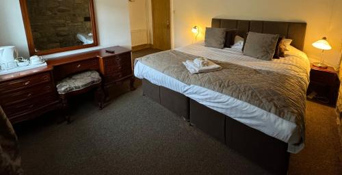 霍特惠斯尔Saughy rigg farm的配有一张大床和镜子的酒店客房