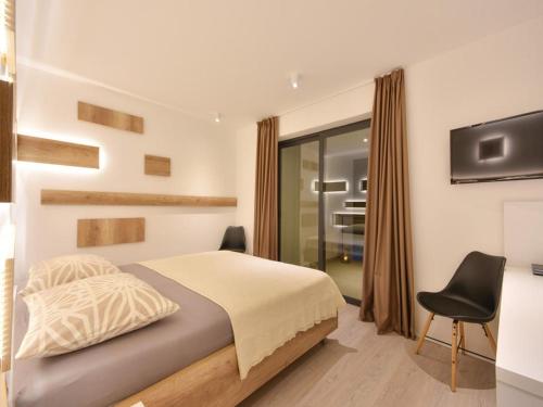 卡什泰拉Villa Formosa的一间卧室配有一张床、一台电视和一把椅子
