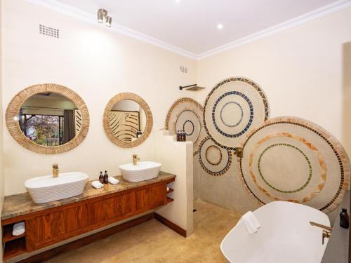 维多利亚瀑布Insika lodge的浴室设有3个水槽和墙上的镜子