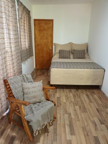 科洛尼亚-德尔萨克拉门托Leia's House的一间卧室配有一张床、一把椅子和一张床