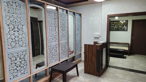 瓦拉纳西NANDI RETREAT HomeStay的一间带木隔板、椅子和桌子的房间