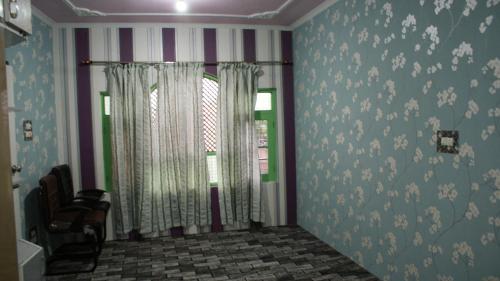 斯利那加Luminaire Homestay的一间设有条纹墙壁和窗帘的窗户的客房
