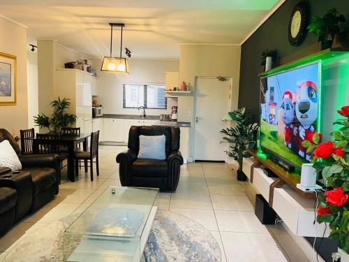 约翰内斯堡M O S Luxury Apartment的客厅设有大屏幕电视和客厅。