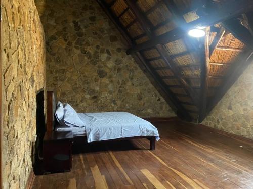 NyangaLovely house on 4 hectares in John Galt Village - 2011的卧室配有一张石墙床