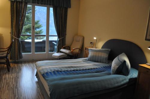 布里恩茨巴伦湖滨酒店的一间卧室设有一张床,享有阳台的景色
