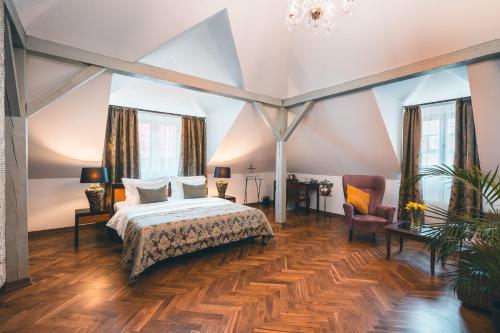 布拉格阿皮亚酒店的一间大卧室,配有一张床和一把椅子