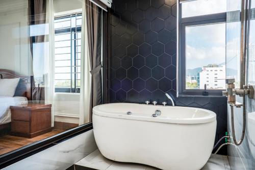 岘港Phu My Hai Hotel的带浴缸和窗户的浴室