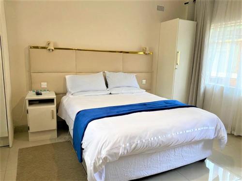 布拉瓦约Luxurious suite with outdoor pool - 2171的一间卧室配有一张带蓝色毯子的大床