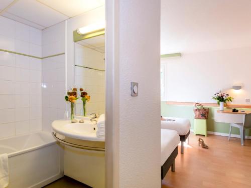 穆然戛纳穆然宜必思快捷酒店的一间带水槽、浴缸和镜子的浴室