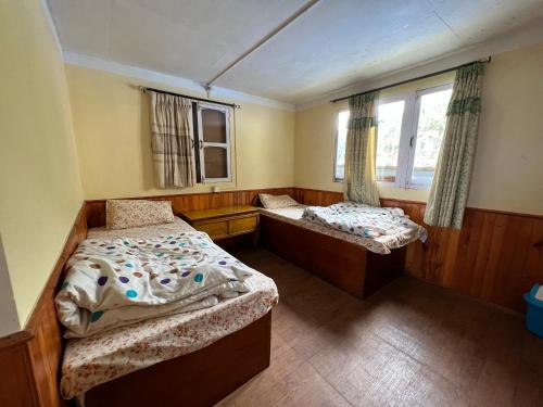 MonjoMount kailash lodge and resturant , Monjo的小房间设有两张床和窗户