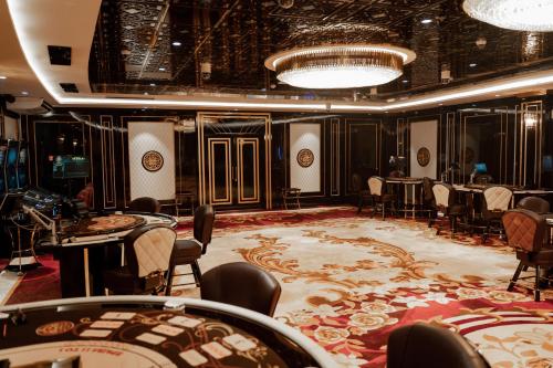 巴统Grand Bellagio Batumi Convention & Casino Hotel的用餐室配有桌椅和大地毯