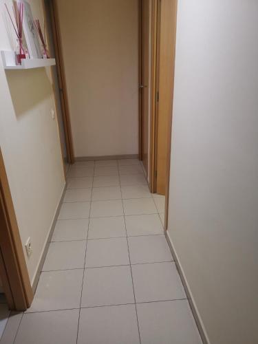 Almenarone Room的走廊铺有白色瓷砖地板,配有冰箱。
