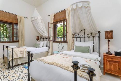 拜特龙La Madrague 3 Bedroom Villa with Garden in Batroun的一间卧室设有两张床和两个窗户。