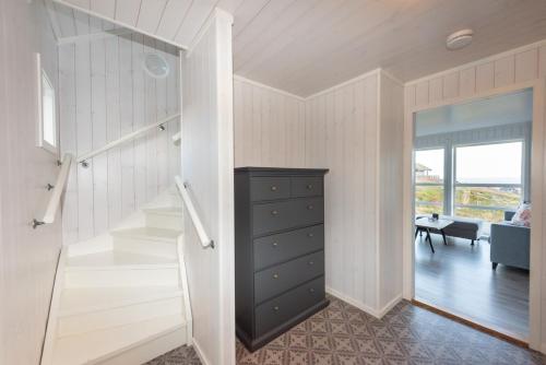 GimsøyModerne hytte på fantastiske Gimsøy i Lofoten的一间房间旁设有楼梯和梳妆台的房间