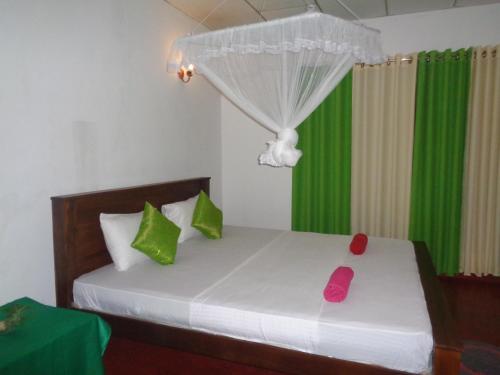 陶尔佩Green Valley Home stay的一间卧室配有带绿色和粉红色枕头的床