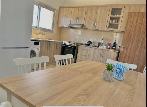 利马索尔Urban Retreat - Your Ideal Getaway in Limassol的厨房配有木桌和桌椅