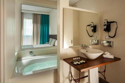 巴兰扎泰Phi Hotel Milano的带浴缸、水槽和镜子的浴室