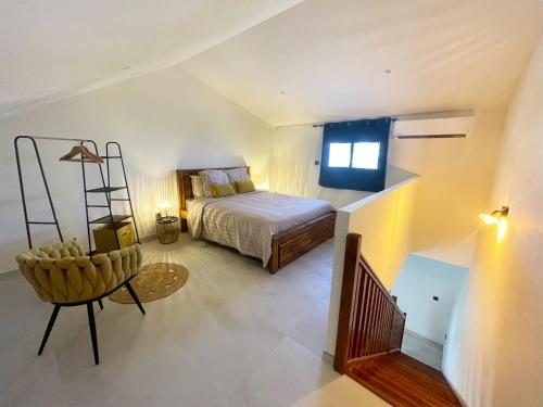 Bras-PanonÔ Ti' Lodge Vanilla的一间卧室,卧室内配有一张床和一把椅子