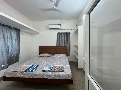 钦奈SAIBALA HOMESTAY - AC 1 BHK NEAR AlRPORT的一间小卧室,配有床和窗户